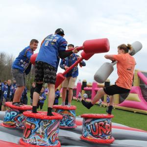 Deelnemers van Basj 2018 spelen een duwspel op een springkasteel