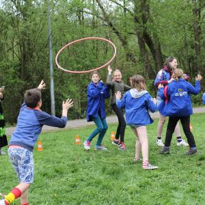 Deelnemers van Triangel 2018 spelen met een hoepel een vangspel
