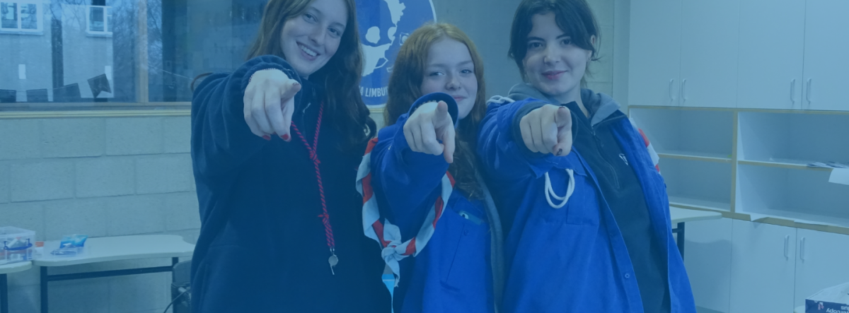 Drie vrolijke vrijwilligers die wijzen naar jou